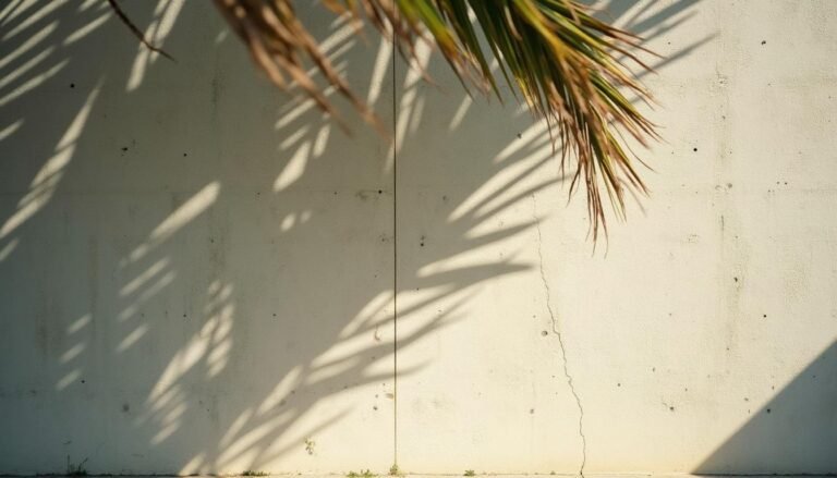 Muro de concreto a la vista con sombras de hojas tropicales en un hotel boutique de El Poblado, Medellín